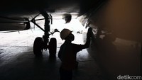 Para petugas membersihkan lambung pesawat dengan seragam lengkap di hanggar GMF, di Cengkareng, Banten.