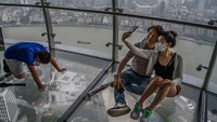 Pengunjung berkumpul di dek observasi di Menara Televisi Oriental Pearl yang menghadap ke Sungai Huangpu di distrik Pudong di Shanghai, China.  