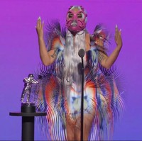 Di MTV VMA 2020, Lady Gaga mendapat sembilan nominasi (terbanyak dari nomine lainnya). Best Collaboration untuk lagu Rain on Me, buah kolaborasinya dengan Ariana Grande, menjadi penghargaan pertama yang disabetnya. Untuk momen tersebut, ia tampil nyentrik dalam balutan gaun Iris van Herpen dengan rumbai warna-warni, berikut masker pink yang hampir menutup seluruh wajahnya. (Foto: MTV via AP)