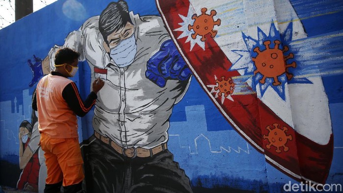 Petugas PPSU Bukit Duri menyelesaikan pembuatan mural yang berisi pesan waspada penyebaran virus Corona di kawasan Bukit Duri, Jakarta, Senin (31/8/2020). Mural tersebut dibuat agar meningkatkan kepatuhan masyarakat dalam menerapkan protokol kesehatan saat beraktivitas karena masih tingginya angka kasus COVID-19. Jumlah kasus harian Corona di DKI Jakarta pada minggu 30 Agustus 2020 memecahkan rekor dan menembus lebih dari 1.100 kasus per hari.
