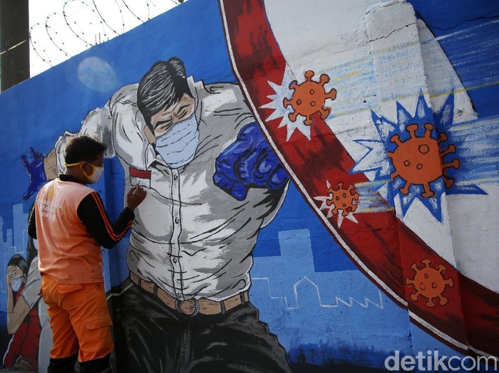 Petugas PPSU Bukit Duri menyelesaikan pembuatan mural yang berisi pesan waspada penyebaran virus Corona di kawasan Bukit Duri, Jakarta, Senin (31/8/2020). Mural tersebut dibuat agar meningkatkan kepatuhan masyarakat dalam menerapkan protokol kesehatan saat beraktivitas karena masih tingginya angka kasus COVID-19. Jumlah kasus harian Corona di DKI Jakarta pada minggu 30 Agustus 2020 memecahkan rekor dan menembus lebih dari 1.100 kasus per hari.