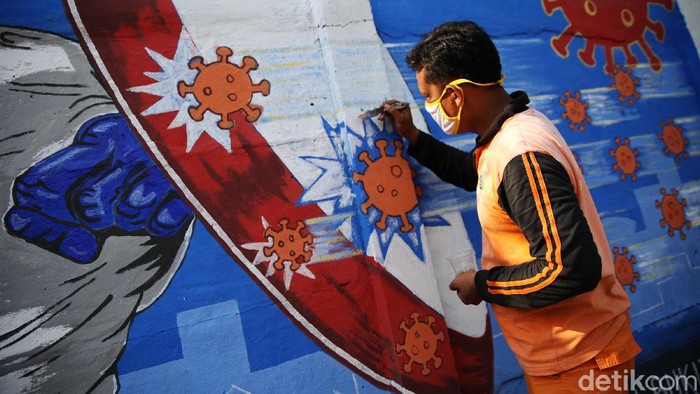 Petugas PPSU Bukit Duri menyelesaikan pembuatan mural yang berisi pesan waspada penyebaran virus Corona di kawasan Bukit Duri, Jakarta, Senin (31/8/2020). Mural tersebut dibuat agar meningkatkan kepatuhan masyarakat dalam menerapkan protokol kesehatan saat beraktivitas karena masih tingginya angka kasus COVID-19. Jumlah kasus harian Corona di DKI Jakarta pada minggu 30 Agustus 2020 memecahkan rekor dan menembus lebih dari 1.100 kasus per hari.
