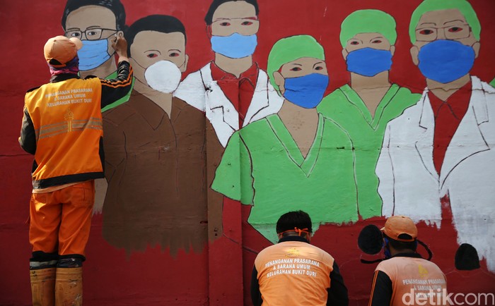Petugas PPSU Bukit Duri menyelesaikan pembuatan mural yang berisi pesan waspada penyebaran virus Corona di kawasan Bukit Duri, Jakarta, Senin (31/8/2020). Mural tersebut dibuat agar meningkatkan kepatuhan masyarakat dalam menerapkan protokol kesehatan saat beraktivitas karena masih tingginya angka kasus COVID-19. Jumlah kasus harian Corona di DKI Jakarta pada minggu 30 Agustus 2020 memecahkan rekor dan menembus lebih dari 1.100 kasus per hari.