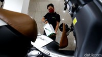 Petugas melakukan uji coba penggantian baterai sepeda motor listrik di halaman kantor Direktorat Jendral Ketenagalistrikan ESDM, Jakarta, Senin (31/8/2020). 