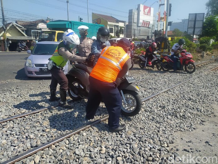 Ratusan sepeda motor dilaporkan jatuh saat lewat perlintasan kereta api di Buduran. Sebab, kerikil di sekitar rel belum diaspal.