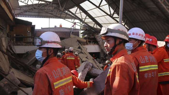 Rescuers search for victims in the aftermath of the collapse of a two-story restaurant in Xiangfen county in northern China's Shanxi province on Saturday, Aug. 29, 2020. More than a dozen were killed after the restaurant collapse during a gathering. (Chinatopix Via AP)