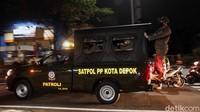 Petugas Satpol PP Kota Depok berkeliling untuk melakukan sosialisasi terkait pemberlakuan jam malam di kawasan Margonda, Depok, Senin (31/8/2020).
