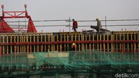 Para pekerja tampak sibuk menyelesaikan proyek pembangunan jalan tol tersebut.