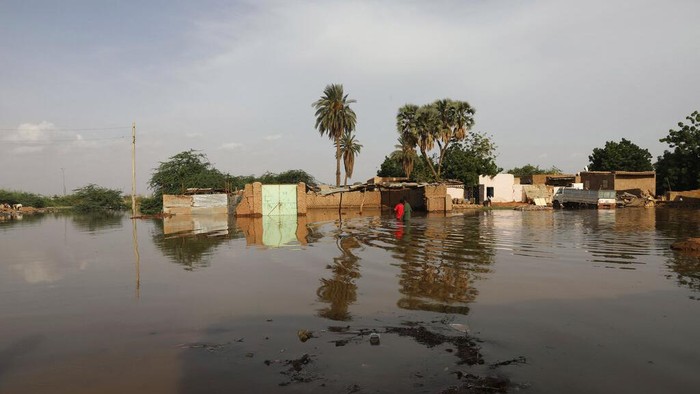 People walk on sandbags to reach their homes in the town of Shaqilab, about 15 miles (25 km) southwest of the capital, Khartoum, Sudan, Monday, Aug. 31, 2020. (AP Photo/Marwan Ali)