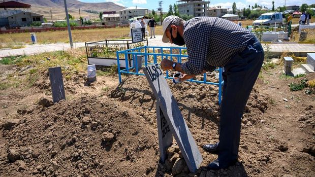 Migrants eat as they shelter next to the Tatvan bus station waiting to take a bus to travel to western Turkey, following their 200 kilometer walk from the Iranian border to Tatvan, on the western shore of Lake Van in Bitlis province on August 24, 2020. - Gravestones scribbled with identity numbers are all that remain of dozens of migrants aboard a boat that sank in a Turkish lake as they struggled to make it to Europe. Lake Van, a vast body of water nearly seven times the size of Lake Geneva, has become a death trap for Afghan, Pakistani and other migrants seeking security and work.The sinking of two boats in June and last December, claiming 68 lives in all, underscores the perils of a route they use to circumnavigate checkpoints set up across the rugged eastern terrain of Turkey, not far from Iran. Hiding on the boat with 60 others that sank on June 27 was Mehdi Mosin, then just 17. (Photo by BULENT KILIC / AFP)