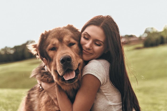 Woman cuddles, plays with her dog at home because of the corona virus pandemic covid-19
