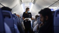 Pramugari membagikan makanan dalam pesawat penerbangan perdana Tel Avis-Abu Dhabi. Nir Elias/Pool Photo via AP.