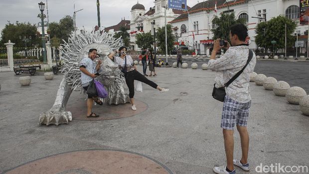Warga berfoto di depan karya seni instalasi berbentuk singa karya seniman Timbul Raharjo yang dipamerkan di kawasan Titik Nol Kilometer, Yogyakarta, Selasa (1/9/2020). Karya seni instalasi sepanjang 8,05 meter dan tinggi 2,35 meter tersebut terbuat dari bahan alumunium menarik wisatawan serta warga yang melintas kawasan titik nol kilometer sebagai tempat berswafoto. detik.com/Pius Erlangga
