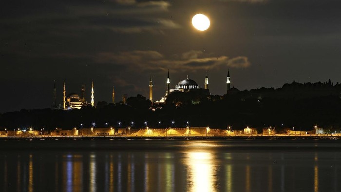The full moon rises behind the Byzantine-era Hagia Sophia in the historic Sultanahmet district of Istanbul, early Tuesday, Sept. 1, 2020. Worshipers held the first Muslim prayers in 86 years inside the Istanbul landmark that served as one of Christendom's most significant cathedrals, a mosque and a museum before its conversion back into a Muslim place of worship on July 24, 2020. The conversion of the edifice, has led to an international outcry. (AP Photo/Emrah Gurel)