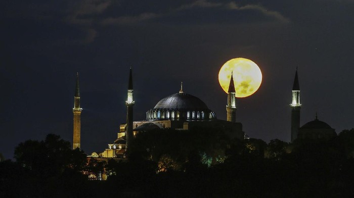 The full moon rises behind the Byzantine-era Hagia Sophia in the historic Sultanahmet district of Istanbul, early Tuesday, Sept. 1, 2020. Worshipers held the first Muslim prayers in 86 years inside the Istanbul landmark that served as one of Christendoms most significant cathedrals, a mosque and a museum before its conversion back into a Muslim place of worship on July 24, 2020. The conversion of the edifice, has led to an international outcry. (AP Photo/Emrah Gurel)