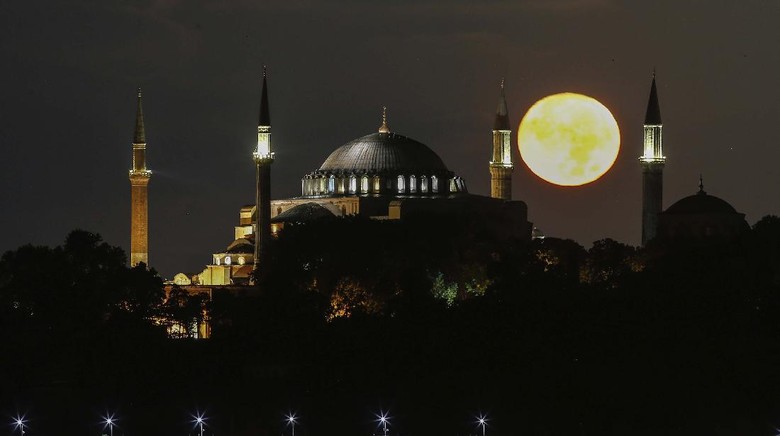 The full moon rises behind the Byzantine-era Hagia Sophia in the historic Sultanahmet district of Istanbul, early Tuesday, Sept. 1, 2020. Worshipers held the first Muslim prayers in 86 years inside the Istanbul landmark that served as one of Christendoms most significant cathedrals, a mosque and a museum before its conversion back into a Muslim place of worship on July 24, 2020. The conversion of the edifice, has led to an international outcry. (AP Photo/Emrah Gurel)