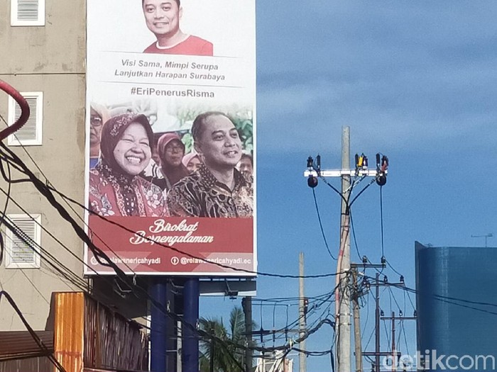 Baliho Kepala Bappeko Surabaya Eri Cahyadi bersama Wali Kota Risma terpampang jelang Pilwali Surabaya. Risma mengaku tidak tahu siapa yang memasang.