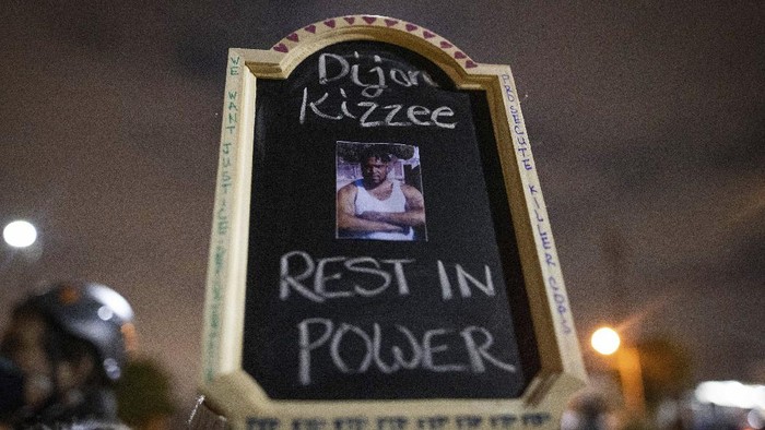 A protester holds a sign with a picture of Dijon Kizzee, who died after being shot by deputies of the Los Angeles Sheriffs Department on Monday, Aug. 31, 2020, in Los Angeles, Calif. (AP Photo/Christian Monterrosa)
