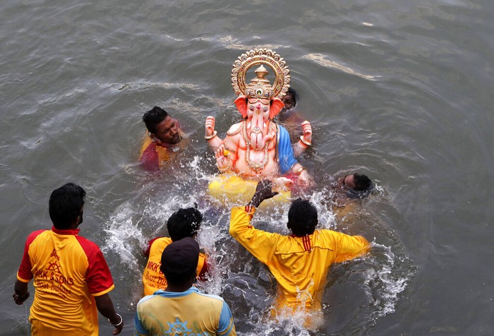Volunteers immerse an idol of elephant-headed Hindu god Ganesha in the Arabian Sea, marking the end of the 10-day long Ganesh Chaturthi festival in Mumbai, India, Tuesday, Sept. 1, 2020. (AP Photo/Rajanish Kakade)