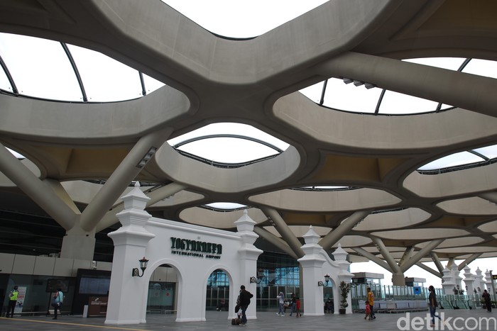Penumpang melintas di area terminal kedatangan dan keberangkatan Bandara Internasional Yogyakarta yang dipenuhi dengan ornament khas Yogyakarta. Bandar udara yang memiliki terminal penumpang seluas 219.000 meter persegi tersebut mampu menampung 20 juta penumpang per tahunnya. Bandara Internasional Yogyakarta telah resmi beroperasi sejak 6 Mei 2019 dengan melayani 13 rute penerbangan domestik.