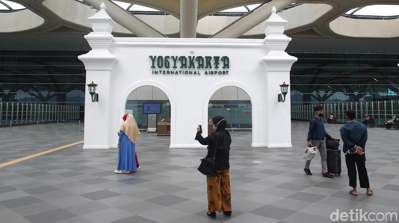 Penumpang melintas di area terminal kedatangan dan keberangkatan Bandara Internasional Yogyakarta yang dipenuhi dengan ornament khas Yogyakarta. Bandar udara yang memiliki terminal penumpang seluas 219.000 meter persegi tersebut mampu menampung 20 juta penumpang per tahunnya. Bandara Internasional Yogyakarta telah resmi beroperasi sejak 6 Mei 2019 dengan melayani 13 rute penerbangan domestik.