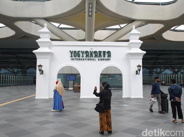 Penumpang melintas di area terminal kedatangan dan keberangkatan Bandara Internasional Yogyakarta yang dipenuhi dengan ornament khas Yogyakarta. Bandar udara yang memiliki terminal penumpang seluas 219.000 meter persegi tersebut mampu menampung 20 juta penumpang per tahunnya. Bandara Internasional Yogyakarta telah resmi beroperasi sejak 6 Mei 2019 dengan melayani 13 rute penerbangan domestik.