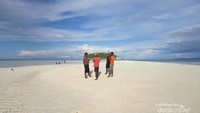 Wisatawan berfoto ria dengan background pulau Koh.