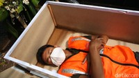 Ada tiga pilihan sanksi kepada para pelanggar PSBB yaitu denda, kerja sosial, atau tidur di replika peti mati.