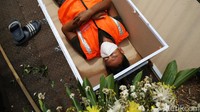 Warga yang tidur di replika peti mati itu juga diingatkan akan bahaya COVID-19.