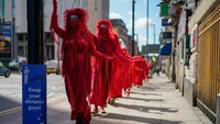 Kelompok Extinction Rebellion mengenakan pakaian yang keseluruhan warna merah dalam aksi protes di beda hari. Christopher Furlong/Getty Images  