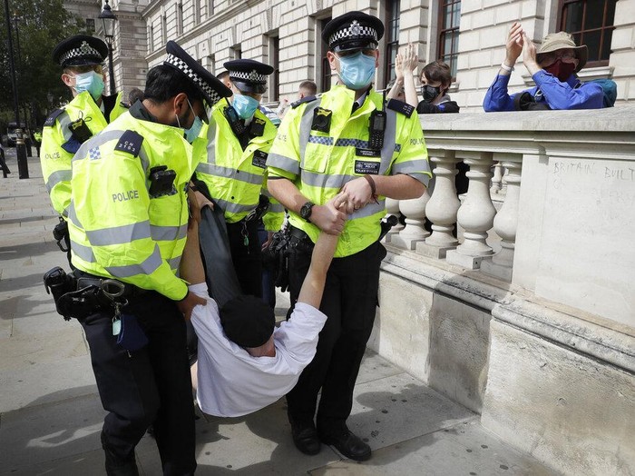 A demonstrator is lifted from the road by police during an Extinction Rebellion climate change protest at Parliament Square in London, Wednesday, Sept. 2, 2020. Hundreds of protesters gathered near Parliament to urge returning lawmakers to support a climate emergency bill and to prepare for a climate crisis. (AP Photo/Kirsty Wigglesworth)