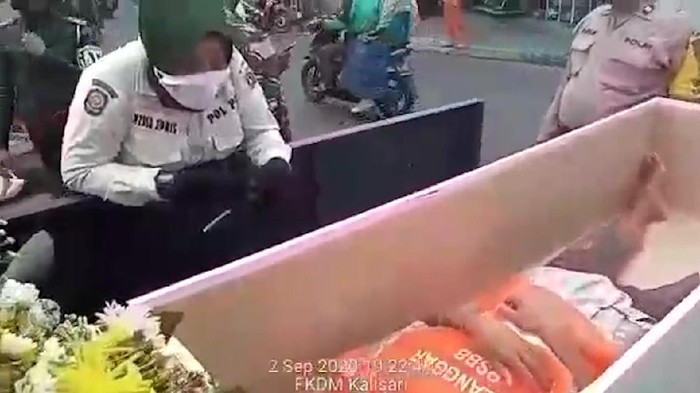 Warga yang masih ngeyel karena tak bermasker di Pasar Rebo Jakarta Timur dimasukkan ke dalam peti mati. Hal itu  sebagai upaya petugas untuk memberikan efek jera terhadap para pelanggar yang mengabaikan protokol kesehatan.