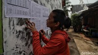 Warga melihat lampiran yang berisi daftar penerima kompensasi bagi warga terdampak pembangunan Jakarta International Stadium (JIS) di kawasan Papanggo, Jakarta, Kamis (3/9/2020).