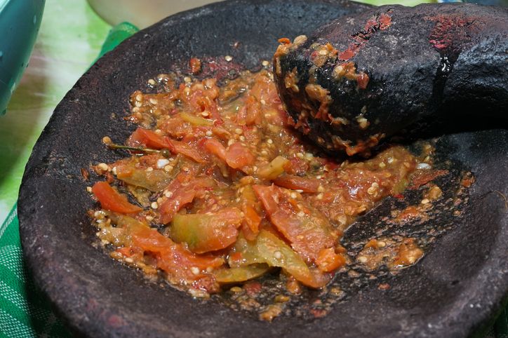 Sambal Lu'at, the popular signature red chili paste from East Nusa Tenggara. Red chili pepper crushed and then mixed with lime juice and shredded basil leaves. The paste is plated on a ceramic plate and served along Se'i Daging, the local smoked meat dish.