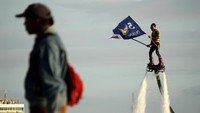 Simpatisan bermain Flyboard sambil membawa bendera partai pengusung pasangan bakal calon Wali Kota dan Wakil Wali Kota Makassar Mohammad Ramadhan Pomanto dan Fatmawati Rusdi saat melakukan deklarasi di Pantai Losari, Makassar, Sulawesi Selatan, Kamis (3/9/2020).