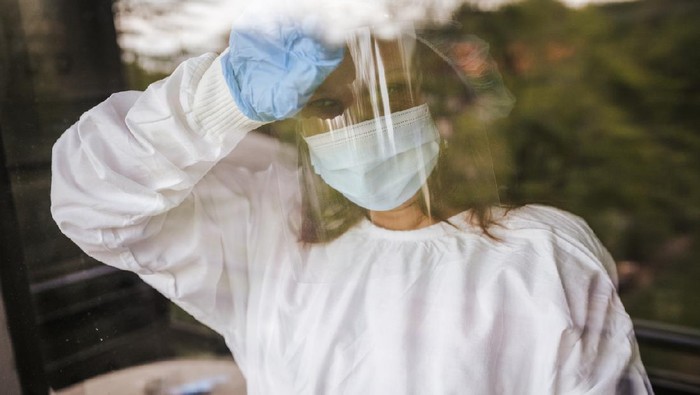 Worried female doctor looking through the window
