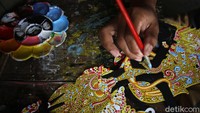 Perajin wayang kulit asal Desa Wukirsari itu sedang menyelesaikan proses pengecetan.