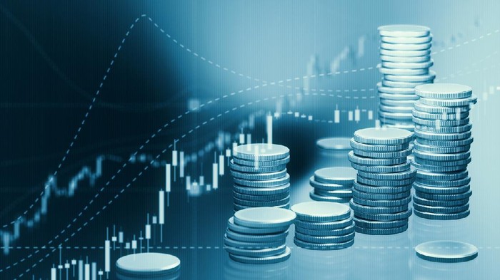 Coin stacks sitting in front of bar graph. Selective focus. Horizontal composition with copy space. Stock market and finance concept.