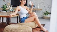 Begini santainya Maria yang mengenakan atasan putih tanpa lengan dan celana pendek saat menikmati secangkir kopinya di pagi hari. Foto: Instagram @maria_vaniaa