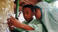 Sejak pandemi COVID-19 dan diterapkannya kebijakan belajar secara daring, sebagian anak di pemukiman tersebut belajar di pos keamanan.