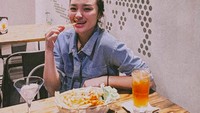 Ngemil kentang goreng, seperti ini pose santai Revina saat di kafe. Segelas es teh jadi penyempurnanya. Foto: Instagram revinavt