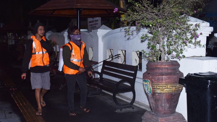 Warga menyemprotkan cairan disinfektan di kawasan pedestrian saat menjalani sanksi pelanggaran tak mengenakan masker, di Kota Madiun, Jawa Timur, Kamis (3/9/2020) malam. Pemkot Madiun memperketat pengawasan pada masyarakat yang melanggar protokol kesehatan guna mencegah penyebaran COVID-19, karena saat ini jumlah kasus positif COVID-19 di wilayah itu terus meningkat. ANTARA FOTO/Siswowidodo/hp.