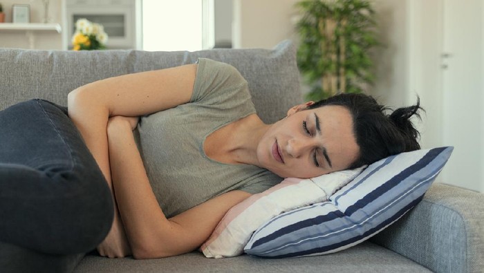 Woman With Abdomen Problems in Bed, She Use Hands to Massage Painful Place. People with diarrhea problem concept. Woman with menstrual pain