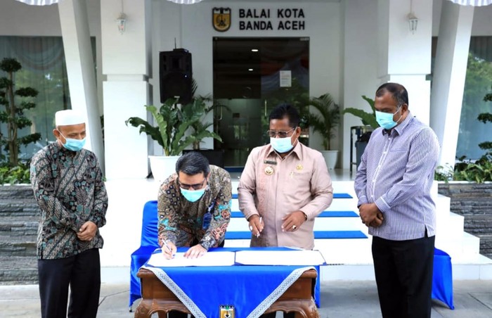 Branch Manager PT Bank Tabungan Negara (Persero) Tbk. Kantor Cabang Syariah Banda Aceh Munawar Solihin bersama Walikota Banda Aceh Aminullah Usman menunjukkan naskah Memorandom of Understanding (MoU) Penyediaan Fasilitas Pelayanan Jasa Perbankan Berdasarkan Prinsip Syariah dalam Lingkungan Pemerintah Kota Banda Aceh disaksikan Kepala Baitul Mal Kota Banda Aceh Asqalani dan Asisten II Pemkot Banda Aceh Bachtiar di Aceh, Jumat (4/9).