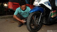 Jasa tambal ban milik Udin tak hanya menarik perhatian karena menggunakan bajaj oranye tetapi juga karena ia tak menggetok harga bagi para warga yang hendak menambal ban di tempatnya.