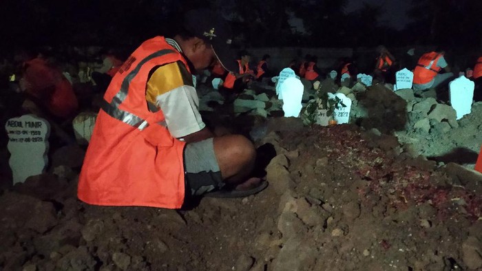 Pelanggar protokol kesehatan berdoa bersama di makam khusus korban COVID-19, di pemakaman Delta Praloyo, Sidoarjo, Jawa Timur, Jumat (4/9/2020) malam. Sebanyak 54 orang pelanggar protokol kesehatan yang terjaring saat razia masker tersebut dihukum berdoa bersama di pemakaman khusus COVID-19 dengan harapan menimbulkan efek jera. ANTARA FOTO/Dimas Kurniawan Trijayanto/ZK/pras.