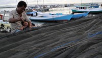 Seorang nelayan memperbaiki jaring di Teluk Kendari, Kendari, Sulawesi Tenggara.