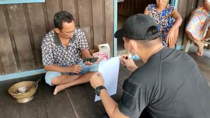 Polisi saat menunjukkan surat pemangilan kepada Effendi Buhing.