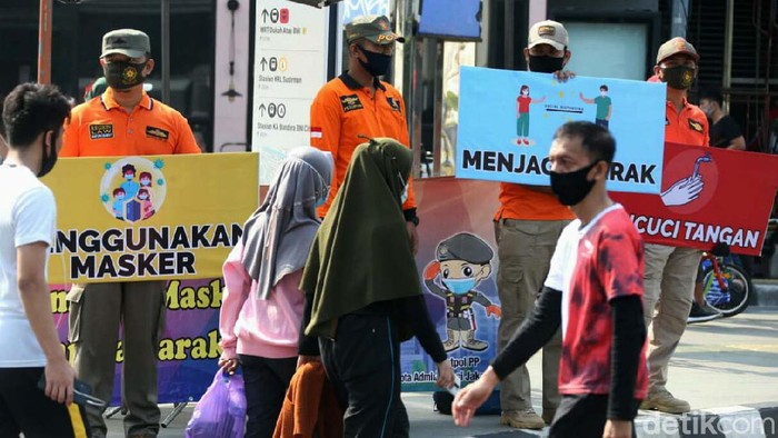 Petugas kepolisian turun langsung ke jalan dalam rangka sosialisasi protokol kesehatan kepada masyarakat. seperti terlihat di Jalan Sudirman-MH Thamrin.