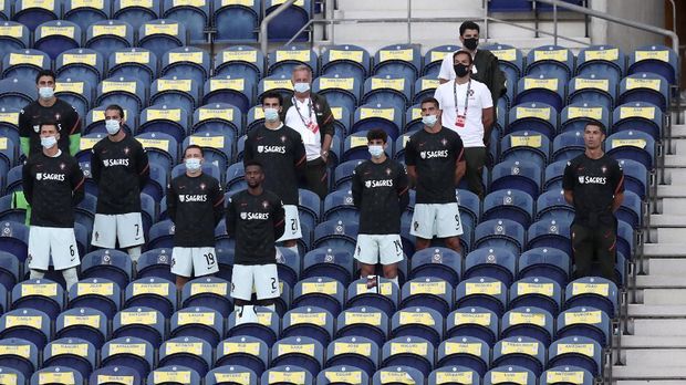 Portugal Kroasia Nations League Soccer Portugal's Cristiano Ronaldo, right, stands next to the team substitutes on the stands during the UEFA Nations League soccer match between Portugal and Croatia at the Dragao stadium in Porto, Portugal, Saturday, Sept. 5, 2020. Ronaldo is not playing due to an injury. (AP Photo/Miguel Angelo Pereira)
